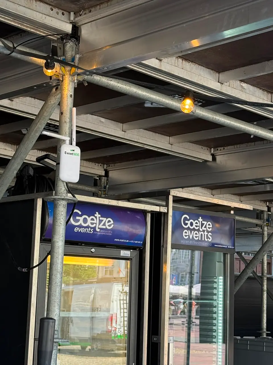 Accesspoint onder de bomen Wifi accesspoint van EventWiFi gemonteerd tegen een muur onder een boom op een stadsfeest