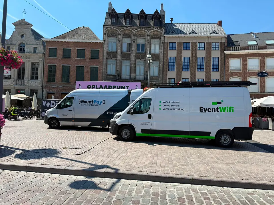 Onze bestelwagen op het plein Bestelwagens van EventWiFi en EventPay op een stadsplein tijdens de opbouw van een stadsfeest